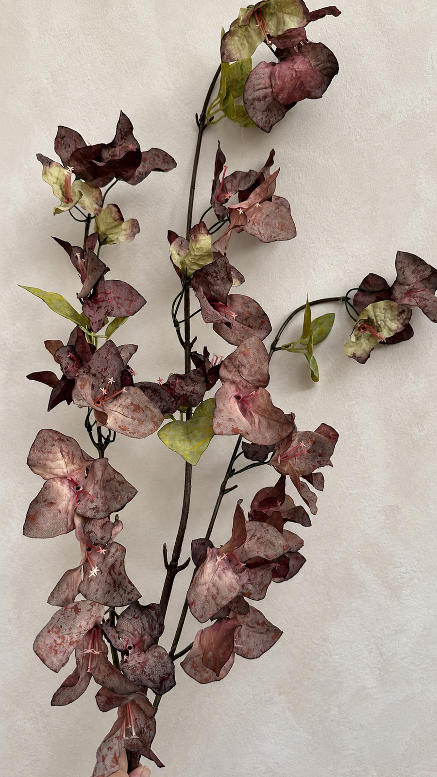 Close-up of Smoky Plum artificial bougainvillea flowers and green leaves