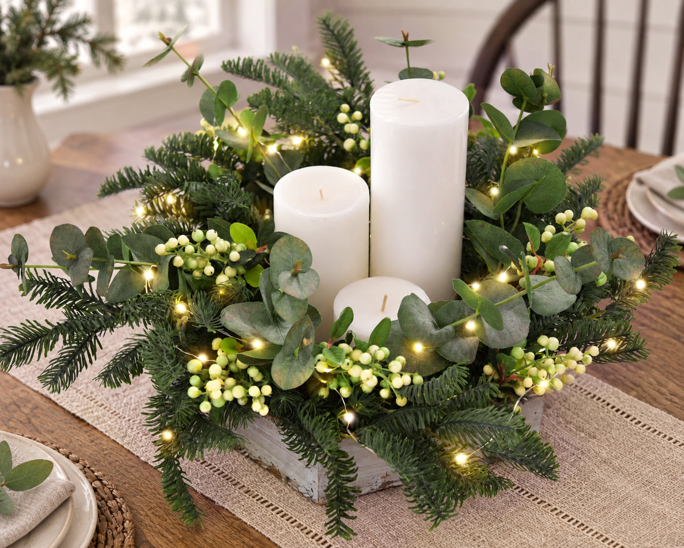 Artificial pine stems styled in a warm farmhouse holiday table centerpiece