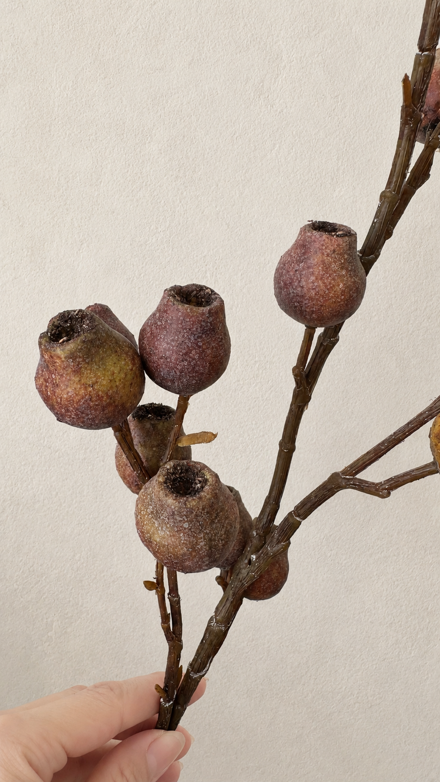 Weathered Russet artificial berry branch close-up with autumn berry texture