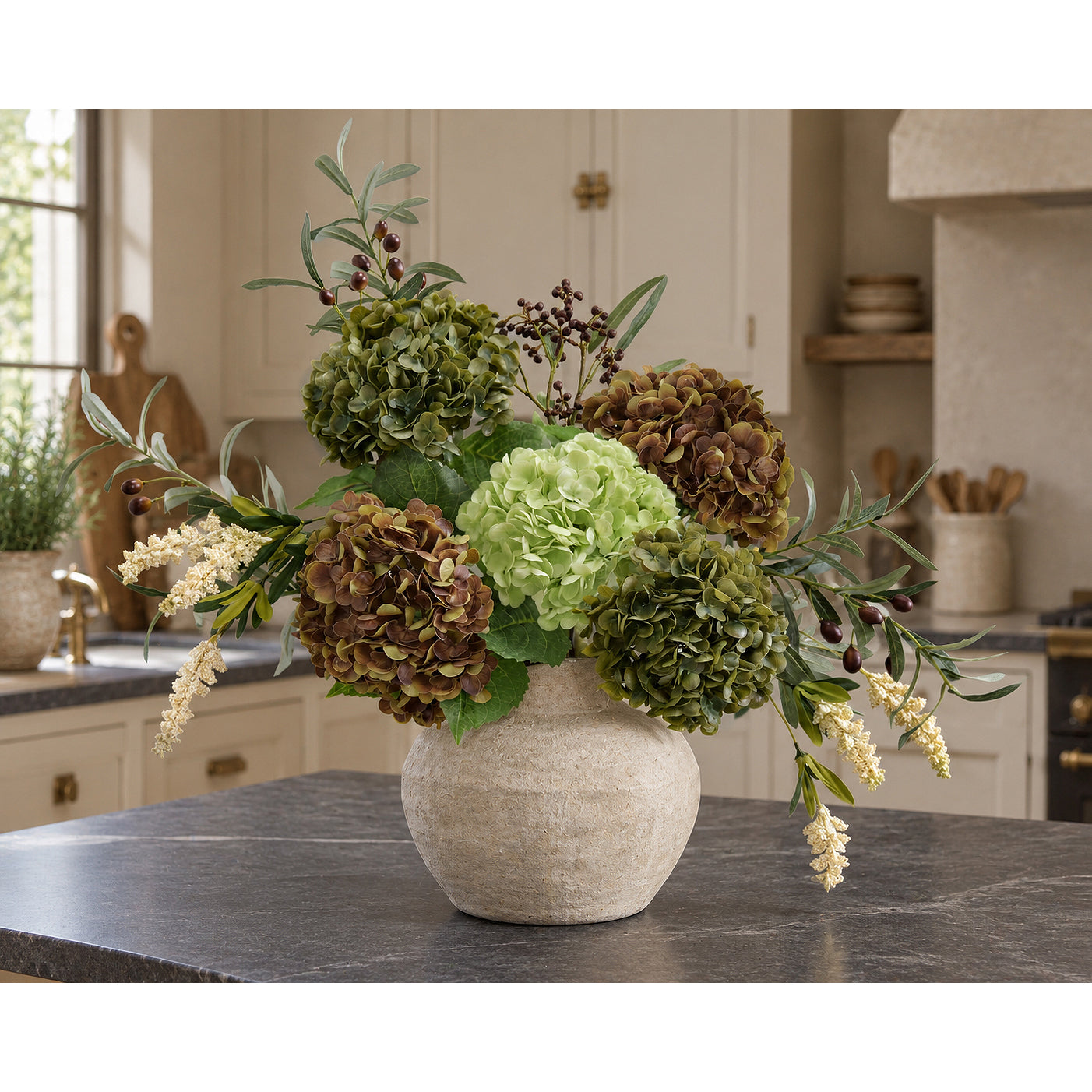 Antique olive hydrangeas with russet and pale green flowers and leafy branches on a kitchen island.