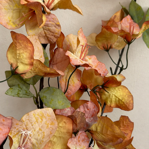 Close-up of Autumn Apricot artificial bougainvillea flowers and green leaves