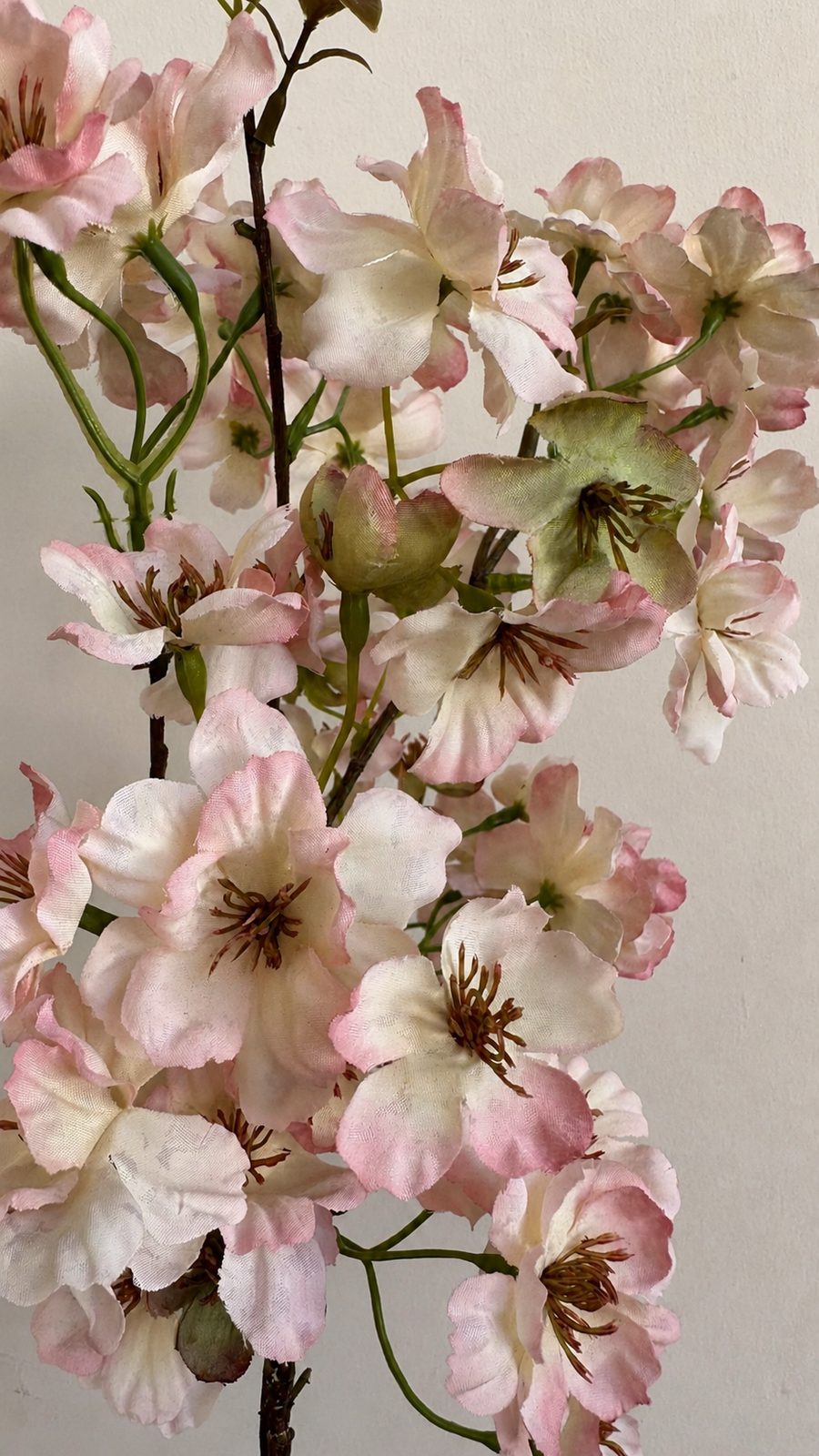 Close-up of blush pink artificial cherry blossom flowers, buds and branch detail