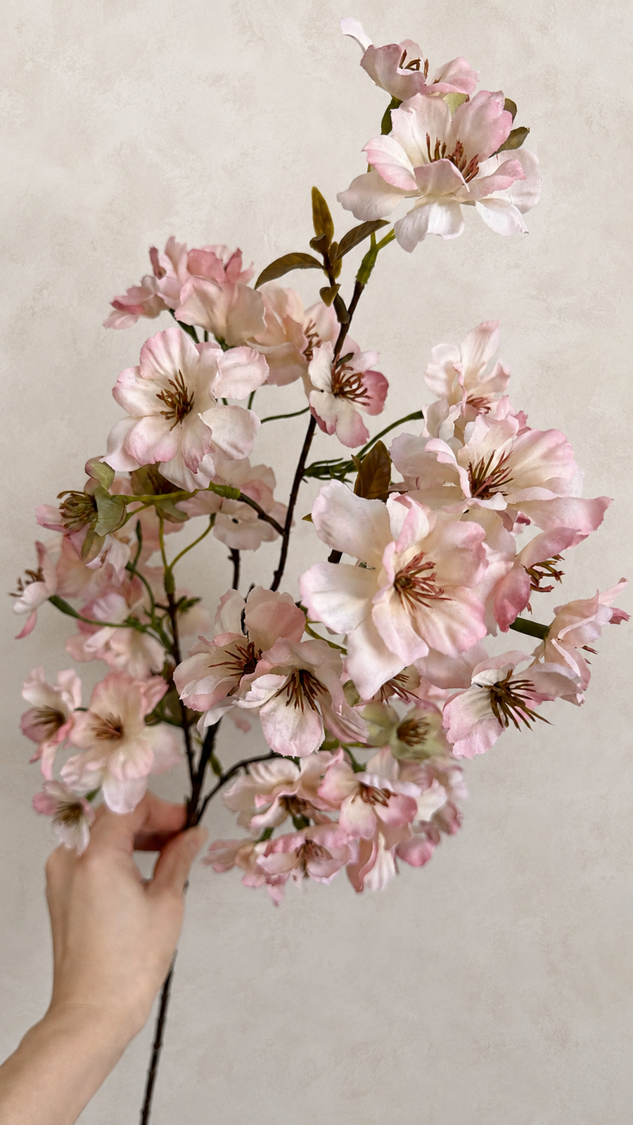 Blush pink artificial cherry blossom branch with layered pale pink and cream blooms