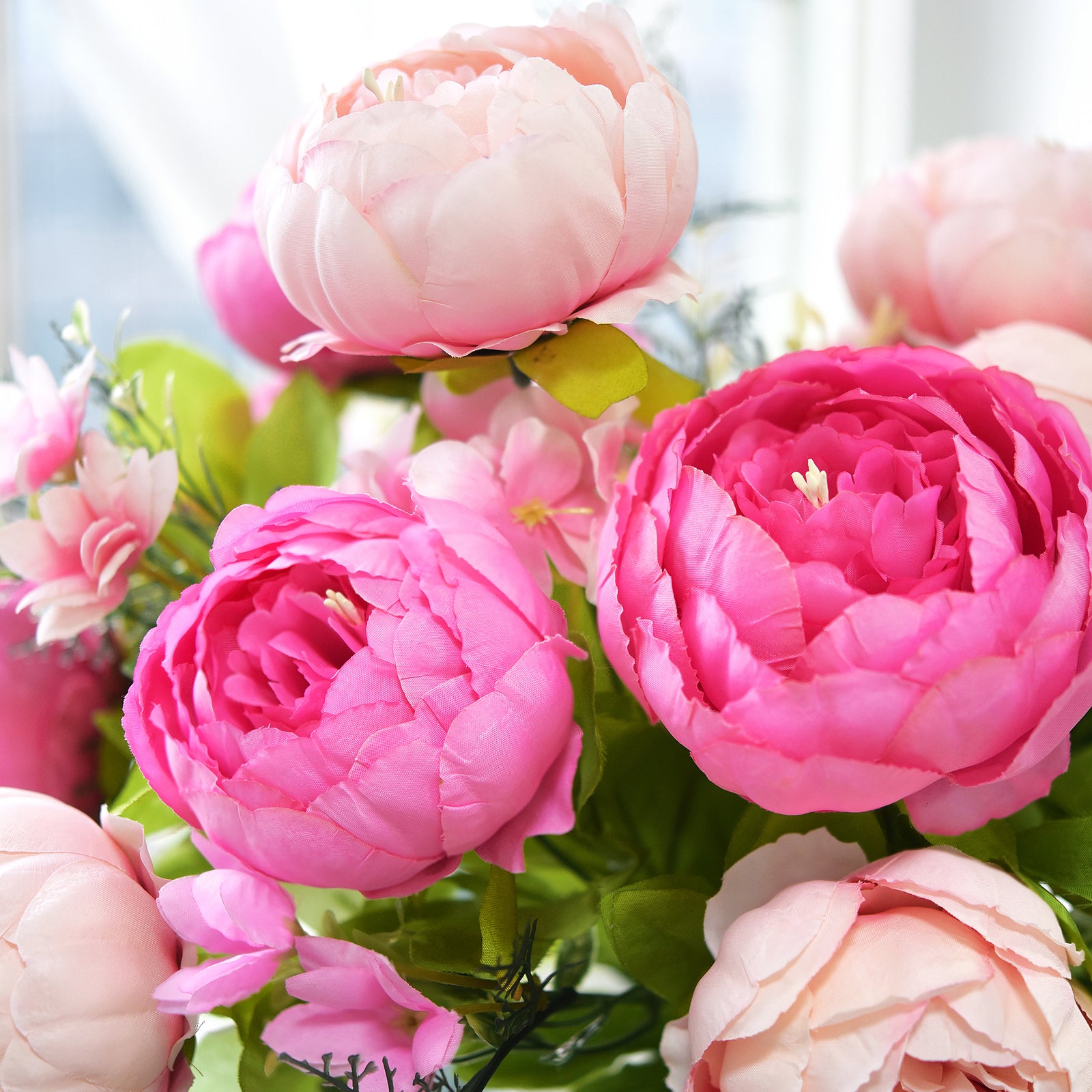 Close-up of blush and pink peonies, showing the texture of realistic silk petals and layered floral construction。