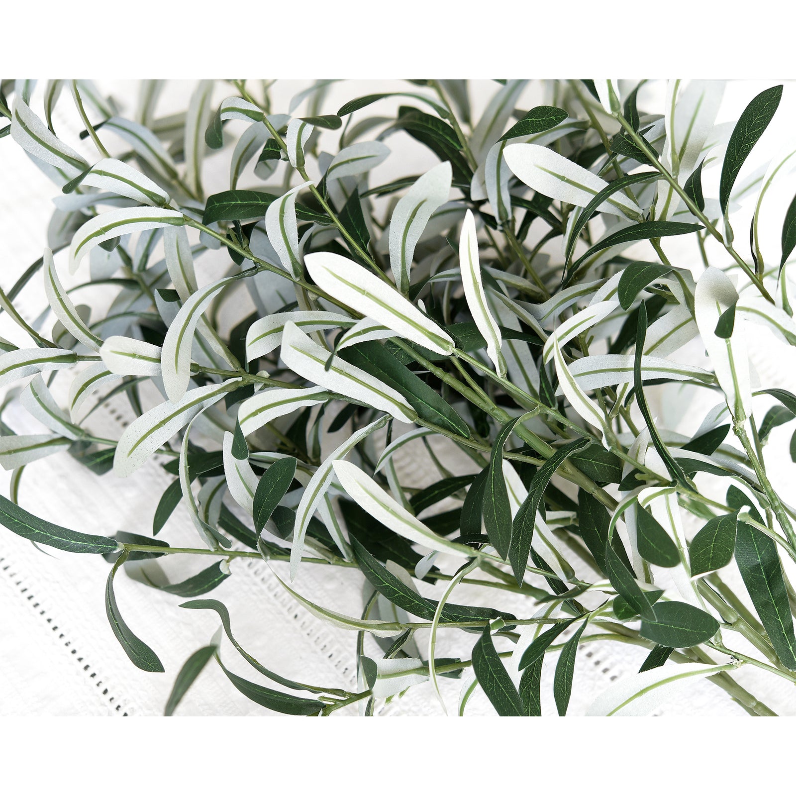 Detailed close-up of artificial olive branch leaves, featuring soft green and silvery tones for a natural look