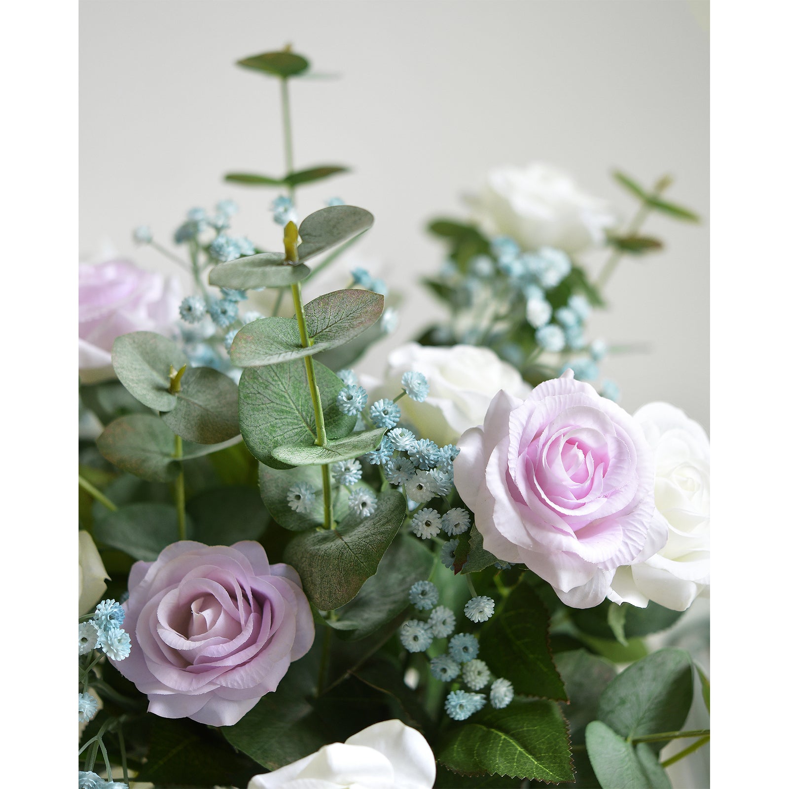 Dusty blue baby's breath nestled between pale pink roses, white flowers and eucalyptus leaves.