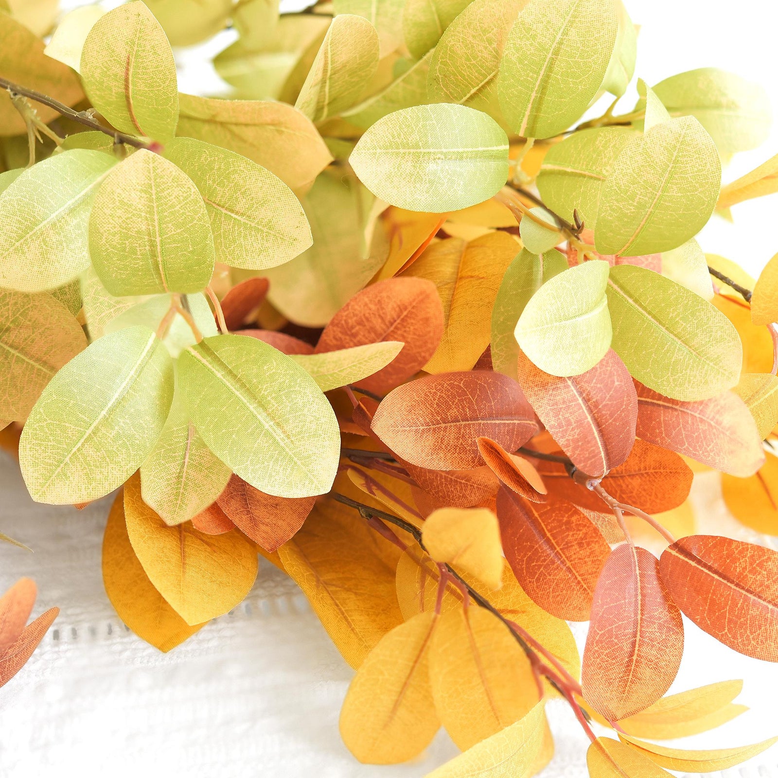 Mixed green, golden yellow and burnt orange artificial fall branches in an alternate view.