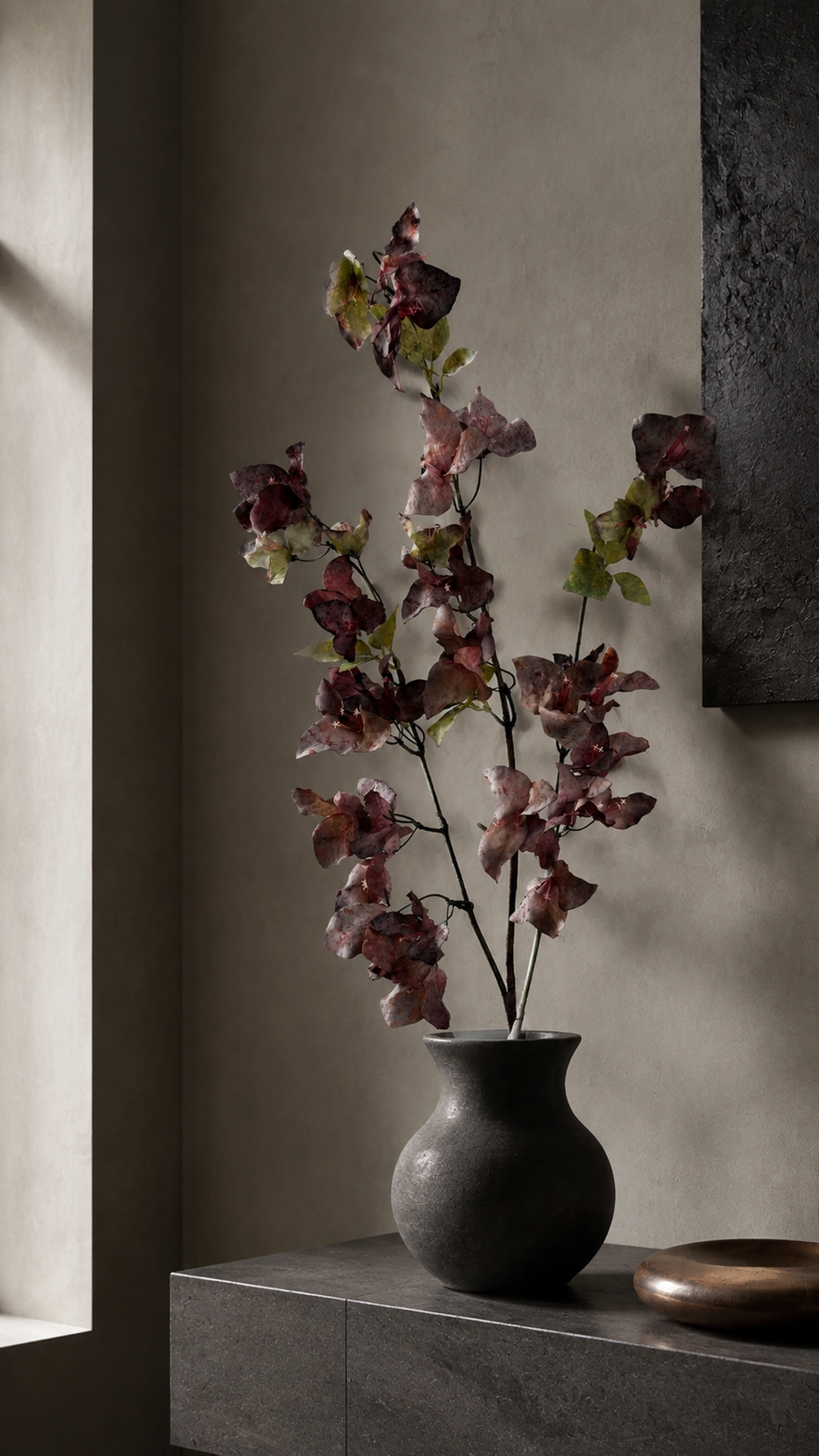 Smoky Plum artificial bougainvillea branch styled in a tall vase in a neutral home interior