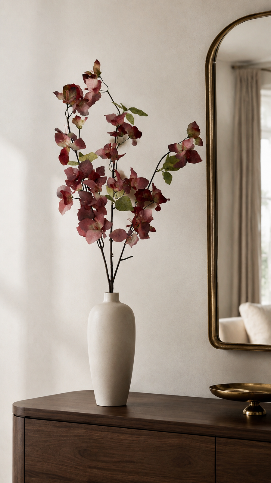 Wine Burgundy artificial bougainvillea branch styled in a tall vase in a neutral home interior