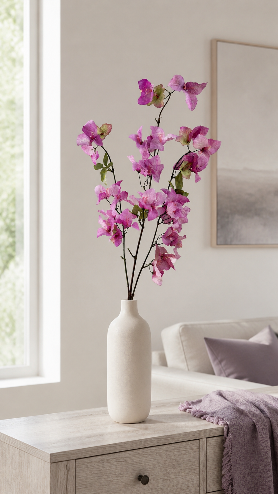 Orchid Purple artificial bougainvillea branch styled in a tall vase in a neutral home interior