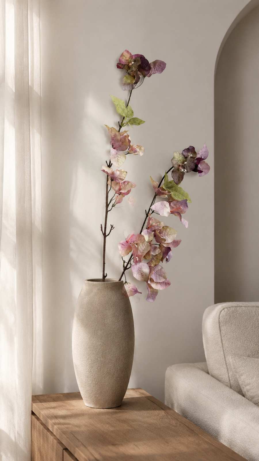 Dusty Mauve artificial bougainvillea branch styled in a tall vase in a neutral home interior