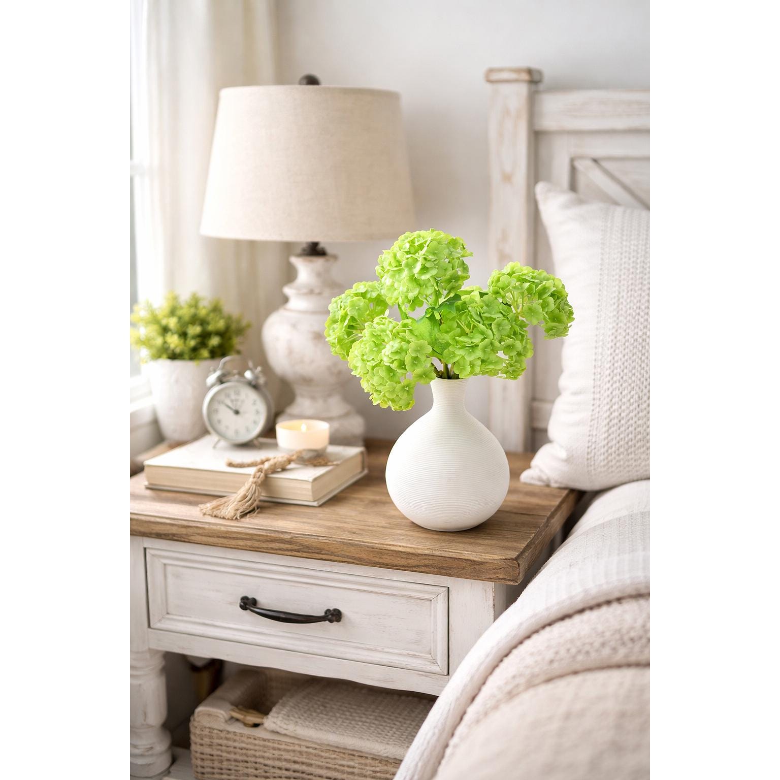 Lime green hydrangea bouquet styled in a white vase on a bedside table.