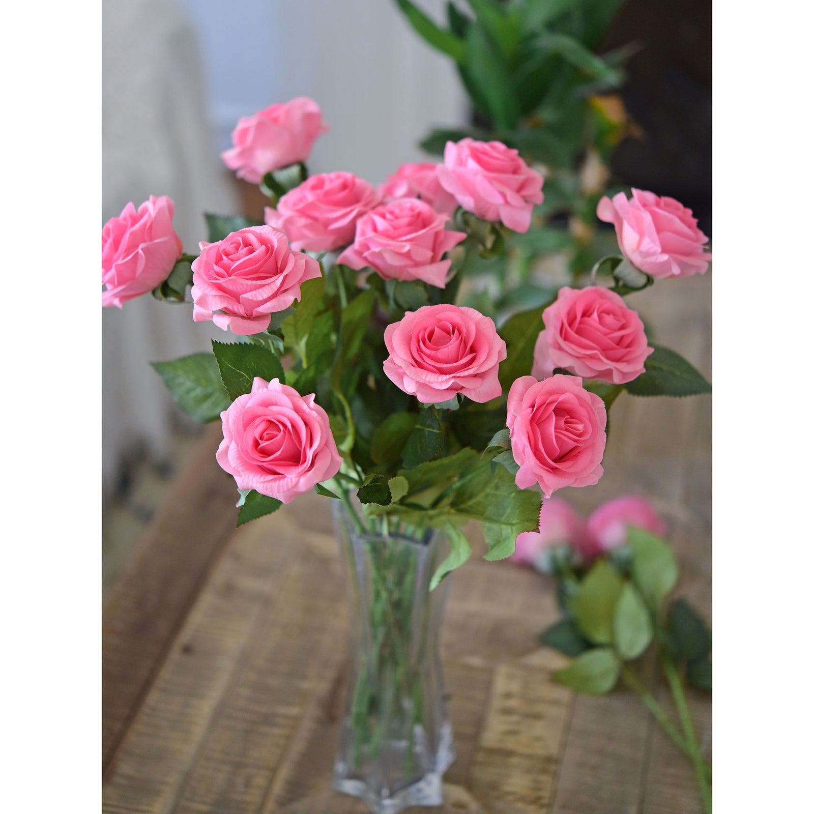 Magenta pink artificial roses showing flower heads and green stems.