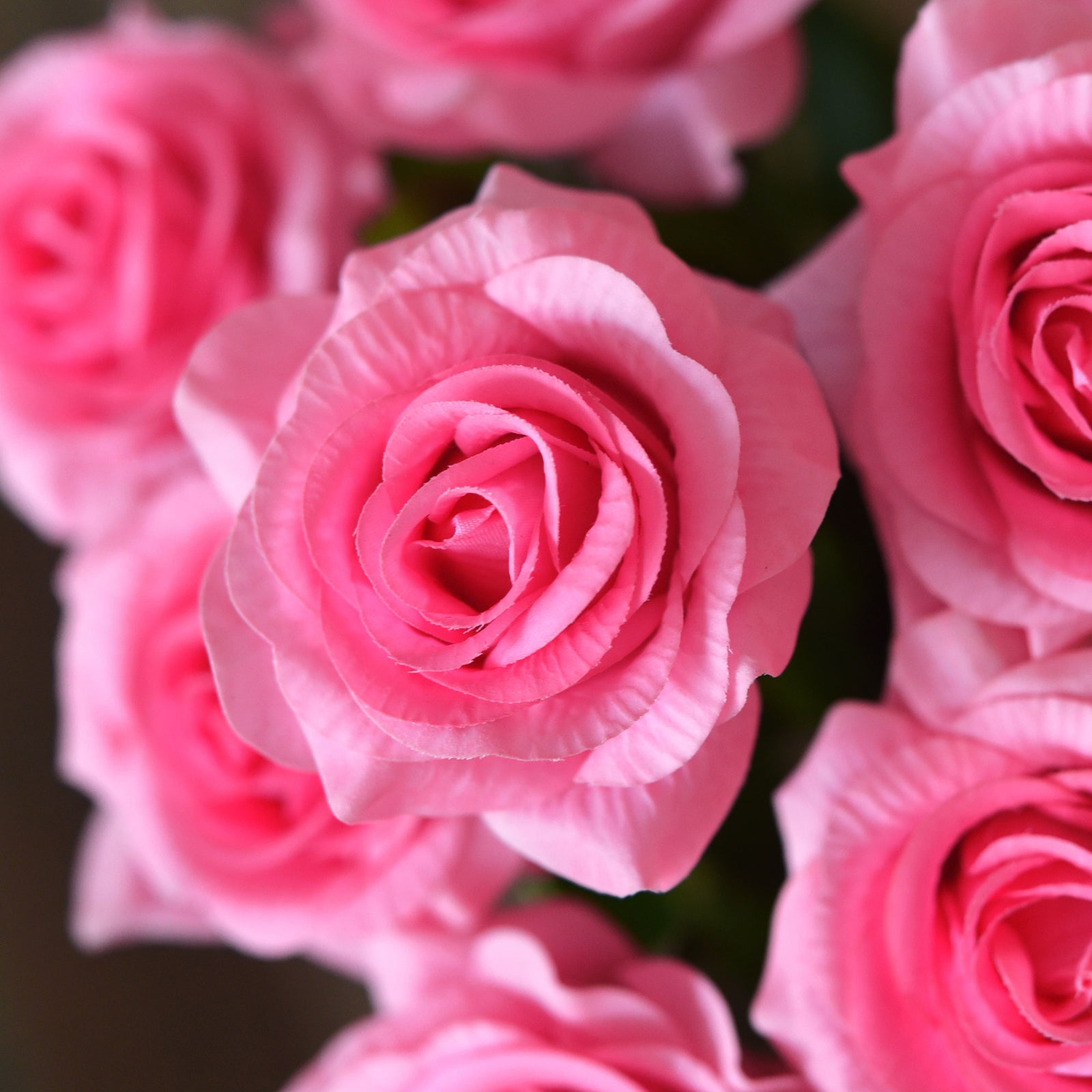 Magenta pink artificial rose stems displayed for centerpiece and bouquet styling.