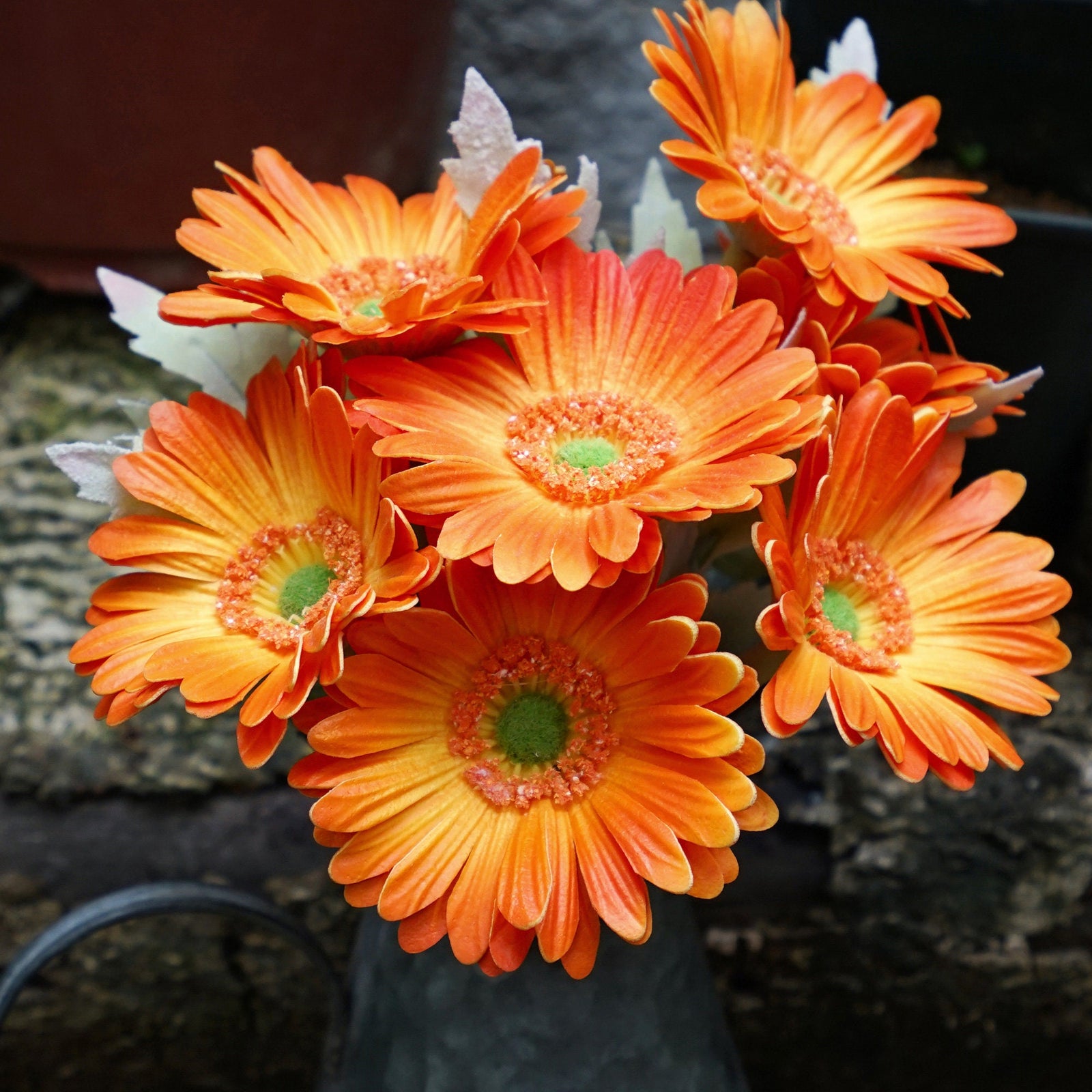 Marmalade orange Real Touch gerbera stems shown with orange blooms and flexible green stems.