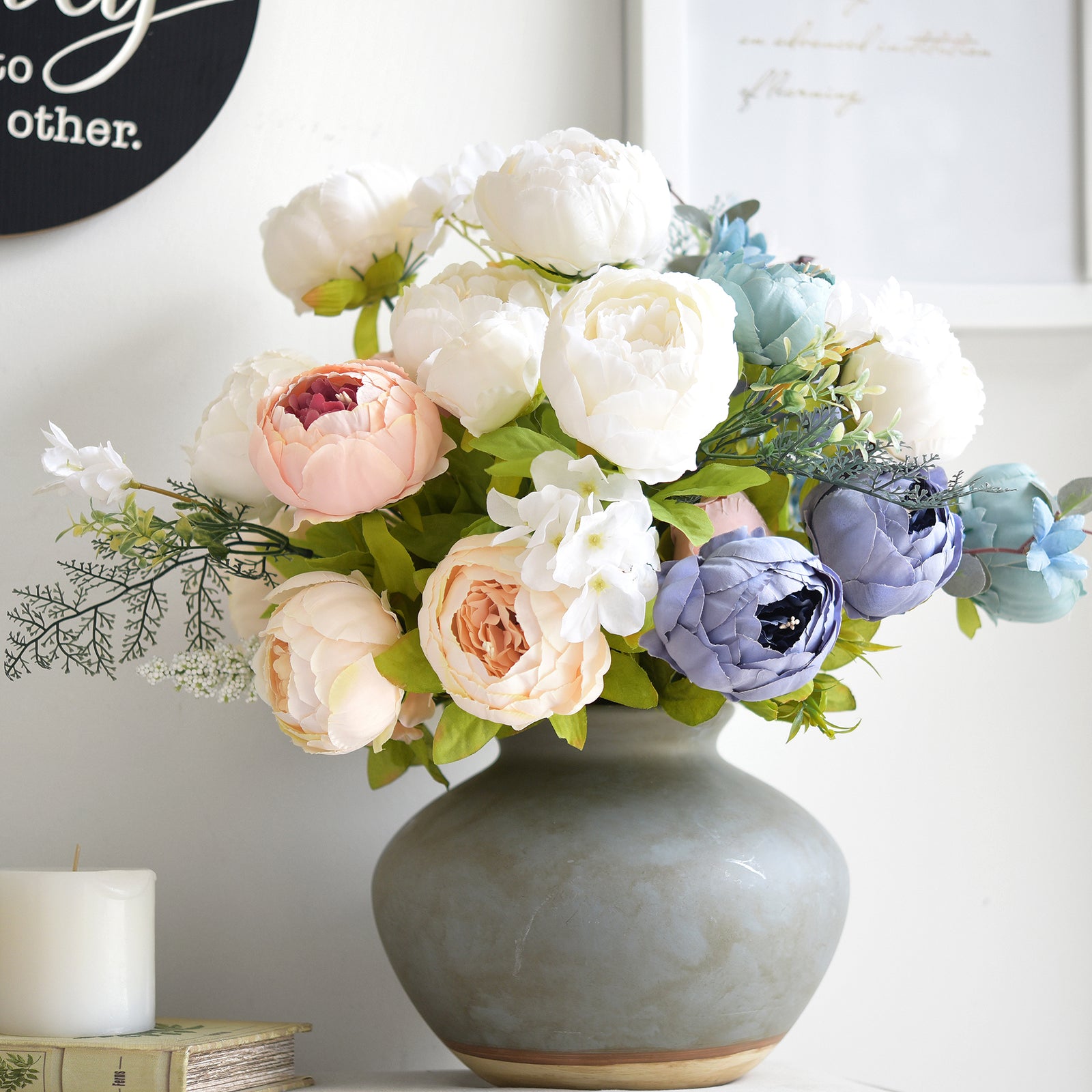 Multicolor peony bouquet with white, pink, and blue flowers, arranged in a rustic grey ceramic vase for seasonal decoration.