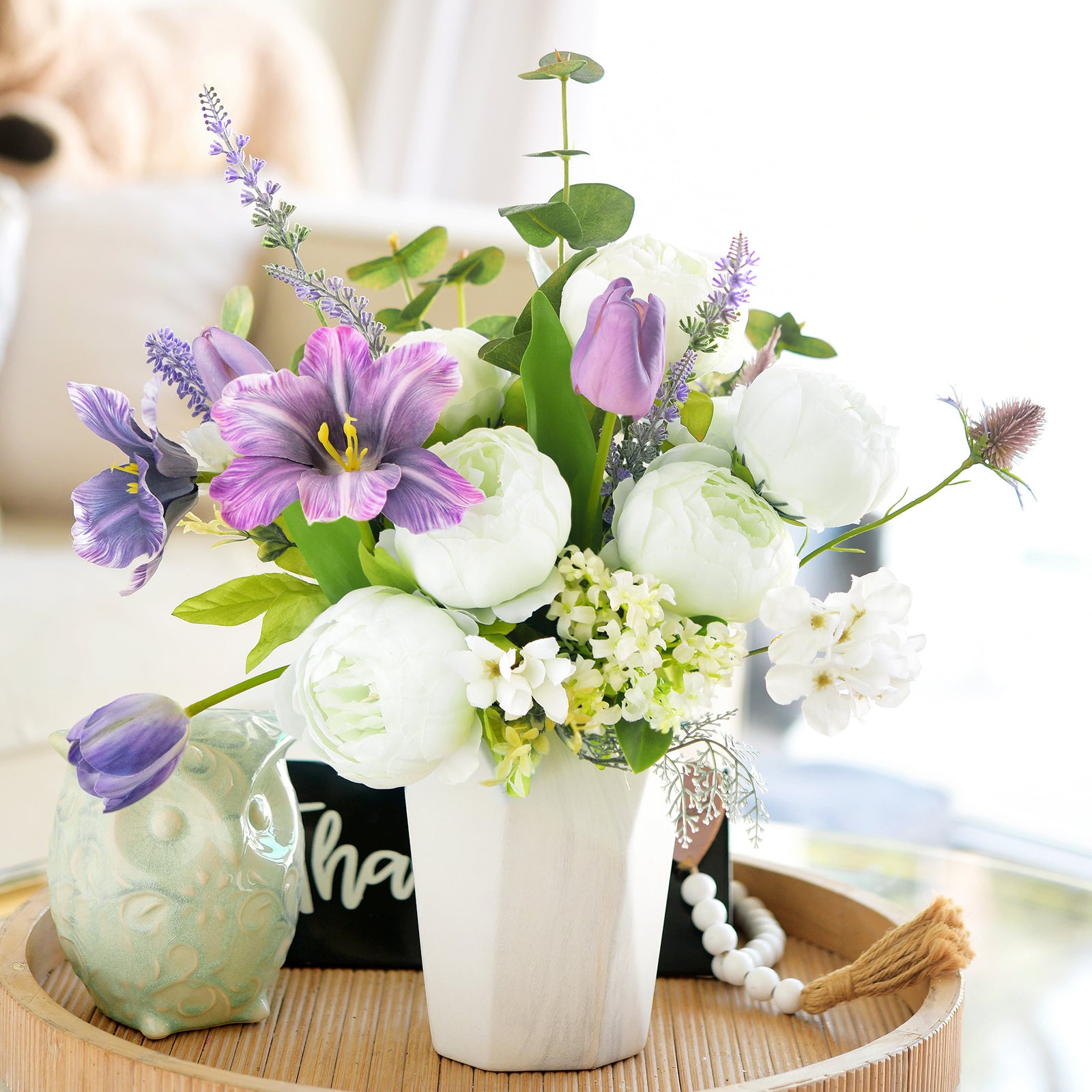 Spring-inspired peony and lavender floral arrangement in a white vase, perfect for brightening living spaces.