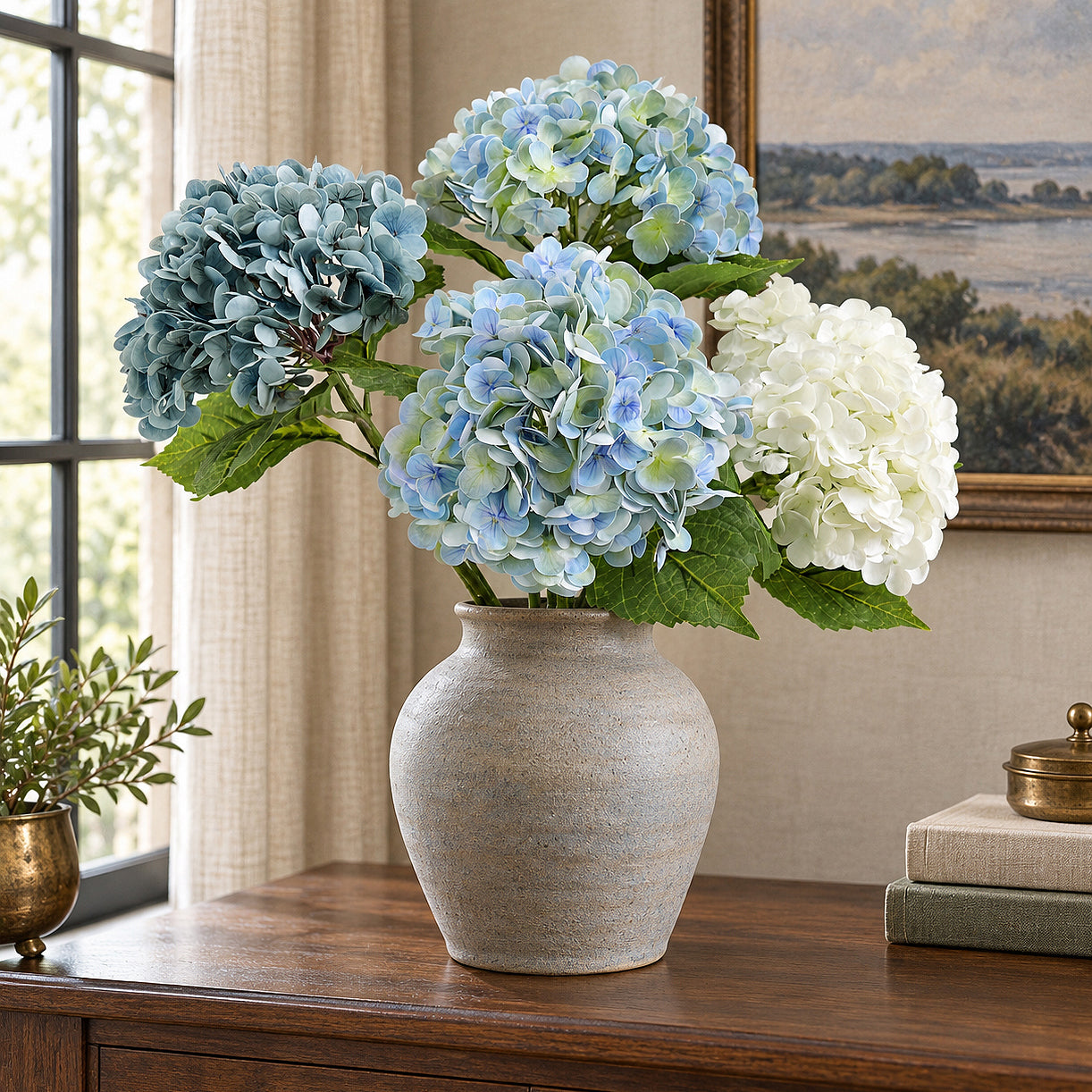 Vintage blue green hydrangeas with dusty slate blue and white blooms in a gray vase on a wood desk.