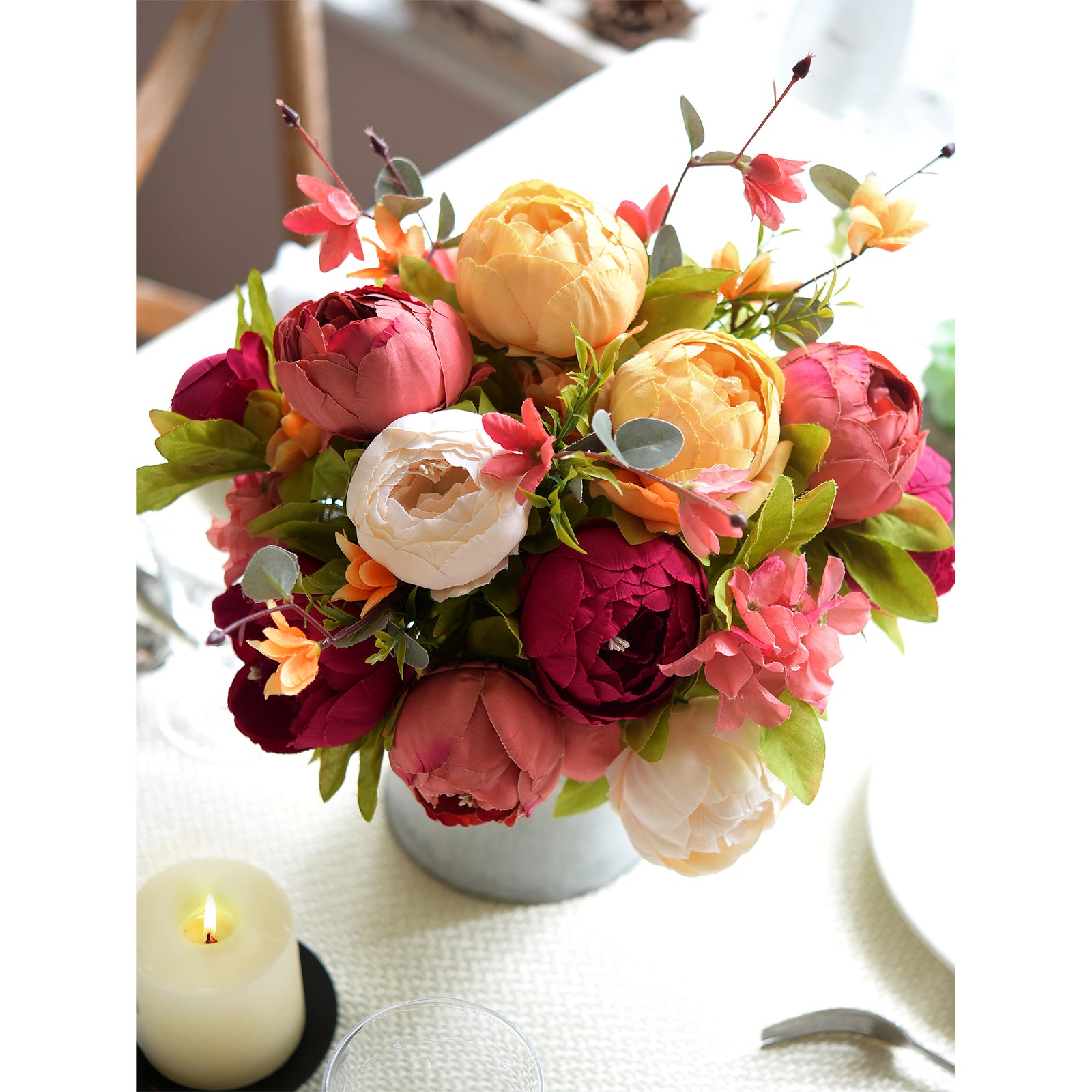 Elegant silk floral arrangement in a vintage-style glass vase with gold taper candle holders, perfect for home decor.