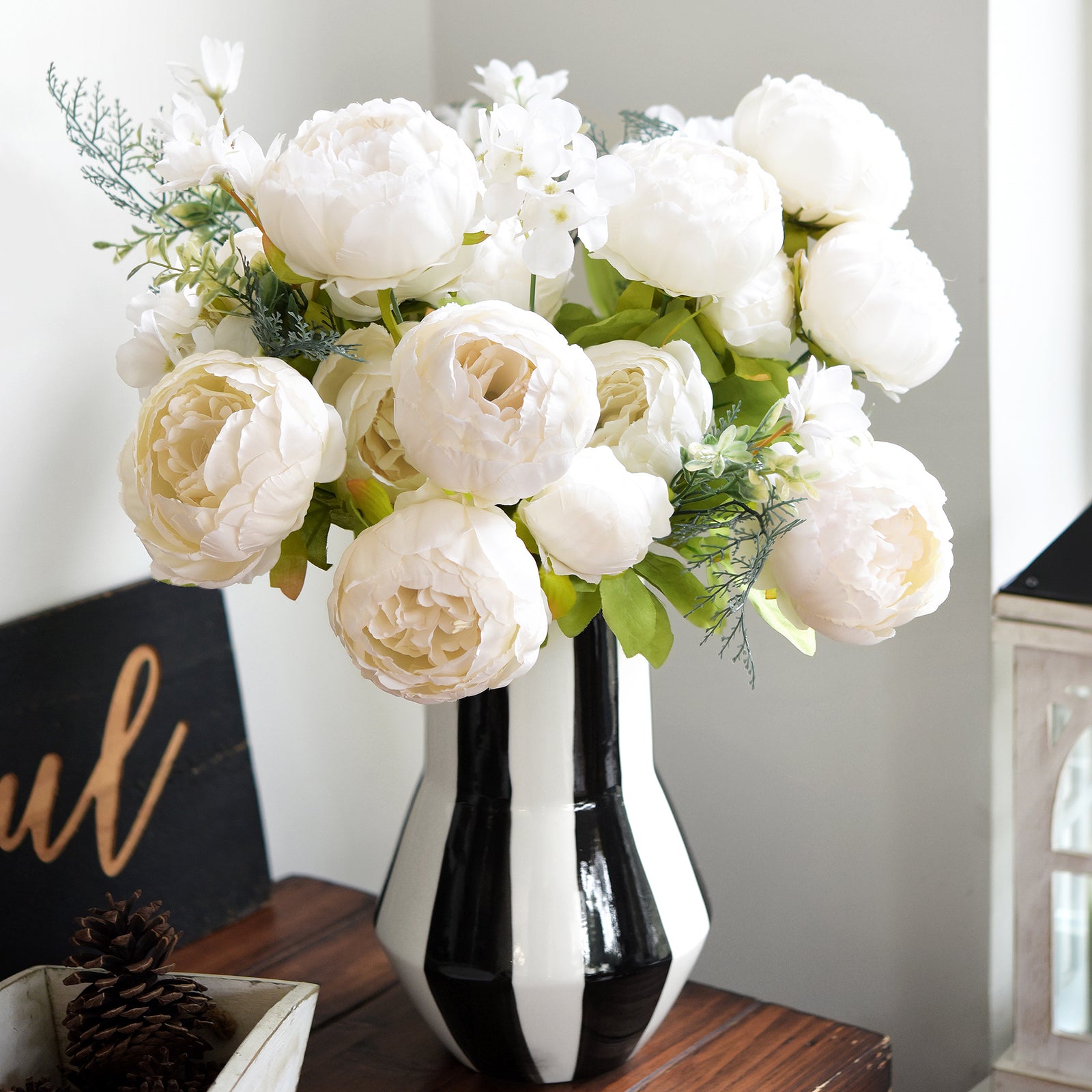 Lifelike white peony bouquet with greenery, styled in a sleek black vase, ideal for modern home or office décor.