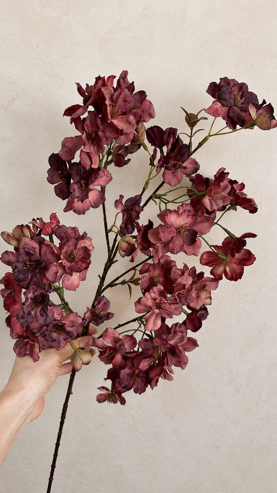 Wine burgundy artificial cherry blossom branch with deep red and muted rose blooms