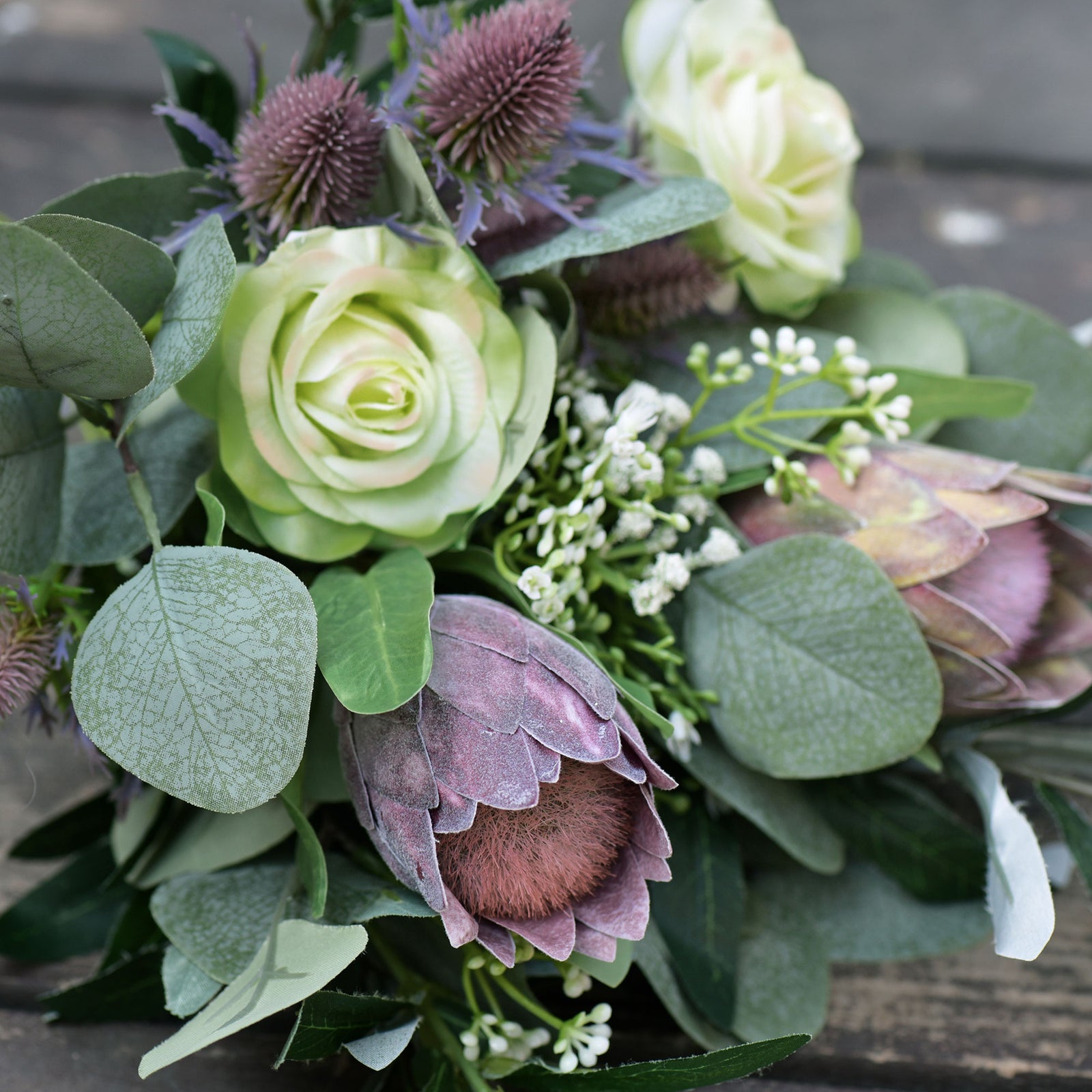 Dusty plum baby protea stems displayed for botanical vase arrangement styling.
