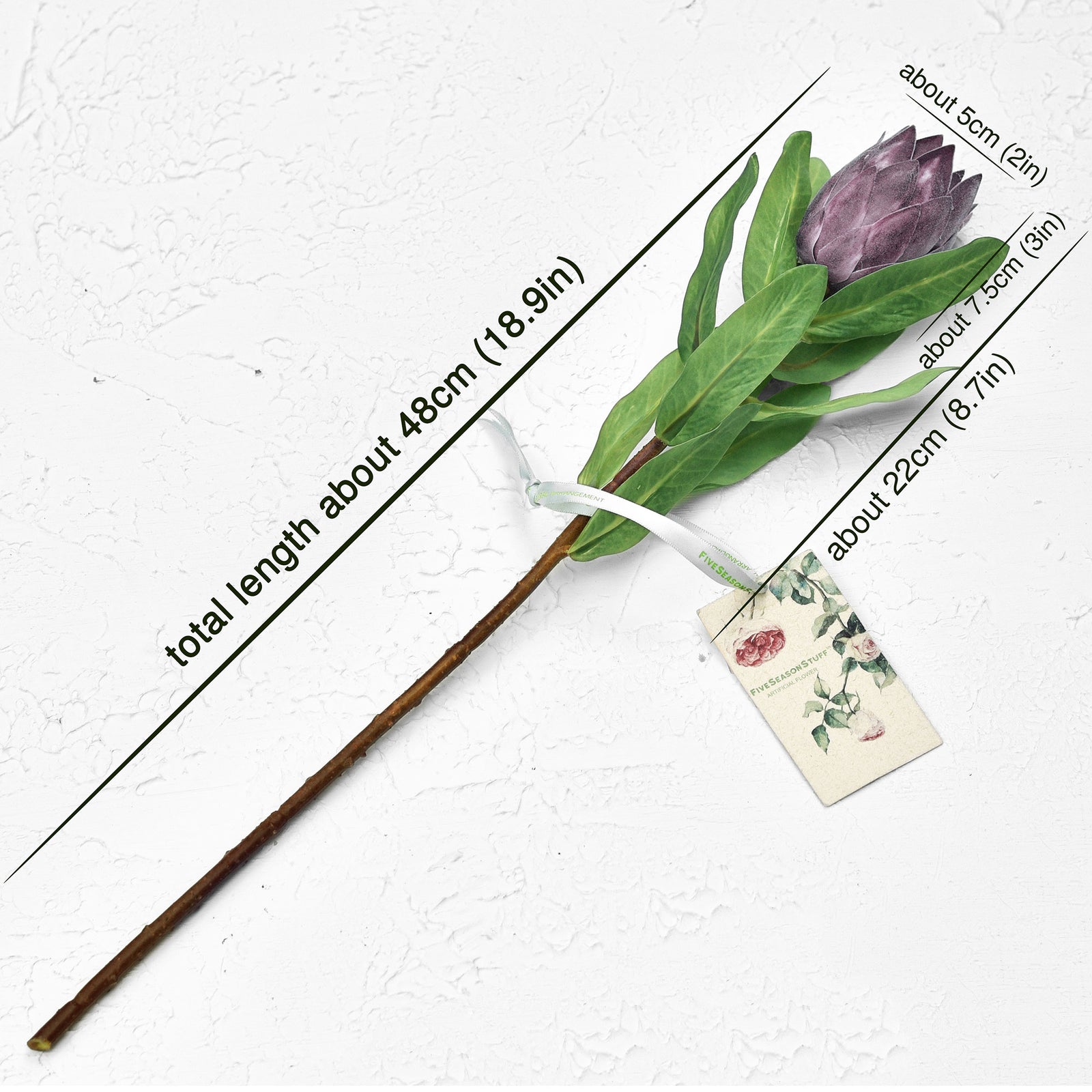 Dusty plum artificial baby protea stems shown gathered for bouquet and vase styling.