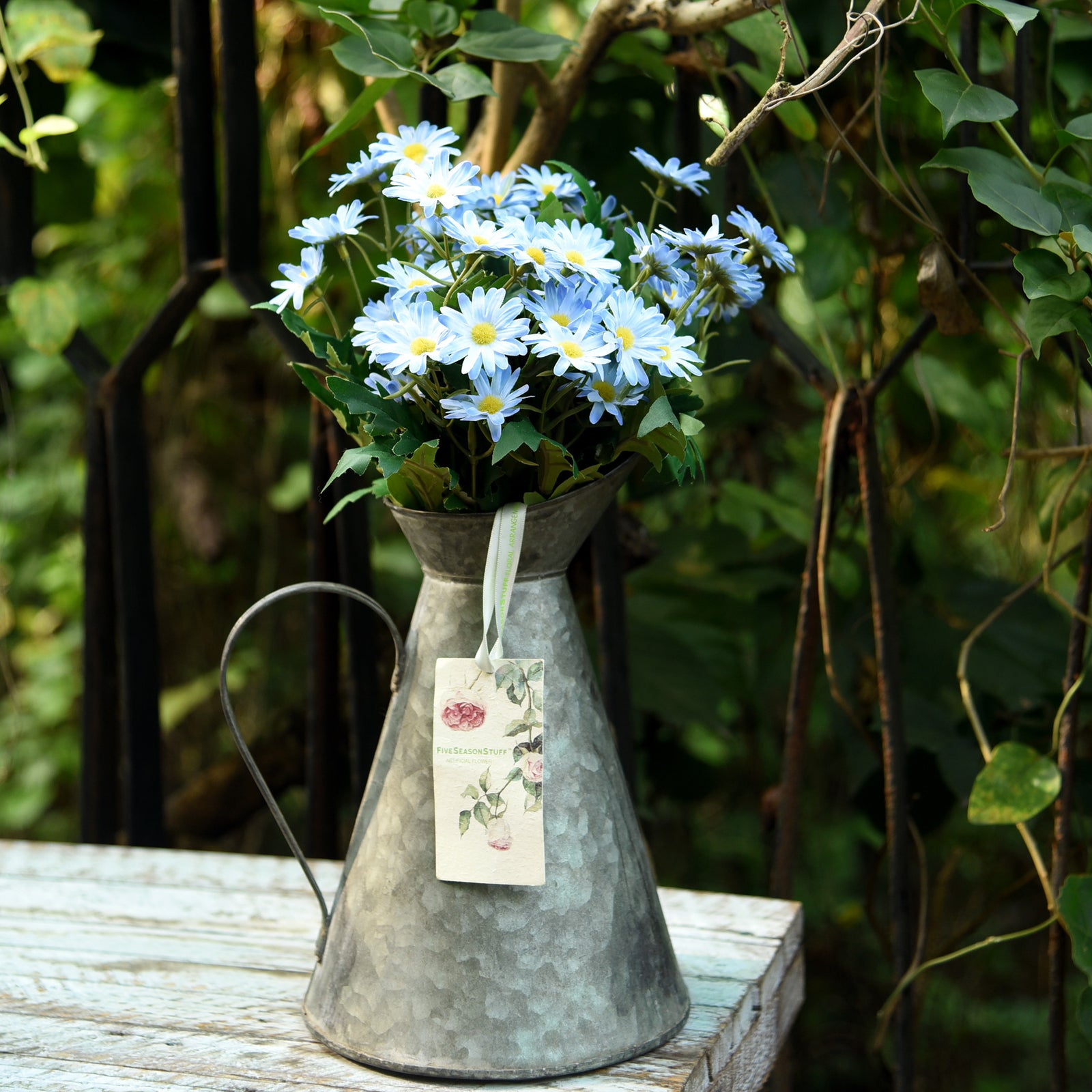 Detail view of Lake Blue artificial daisy blooms and green foliage.