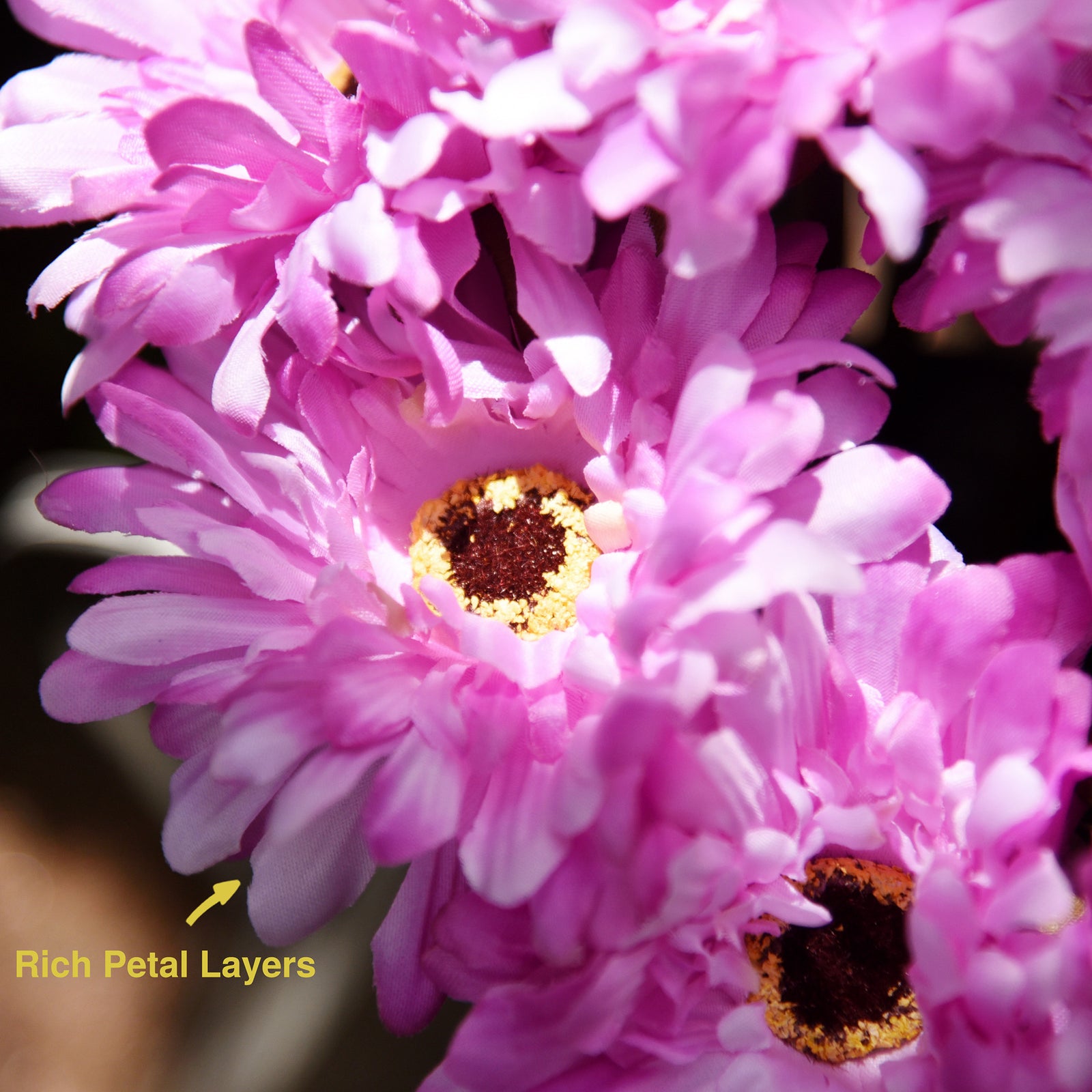 Magenta pink artificial silk gerbera flowers shown with layered blooms and green stems.
