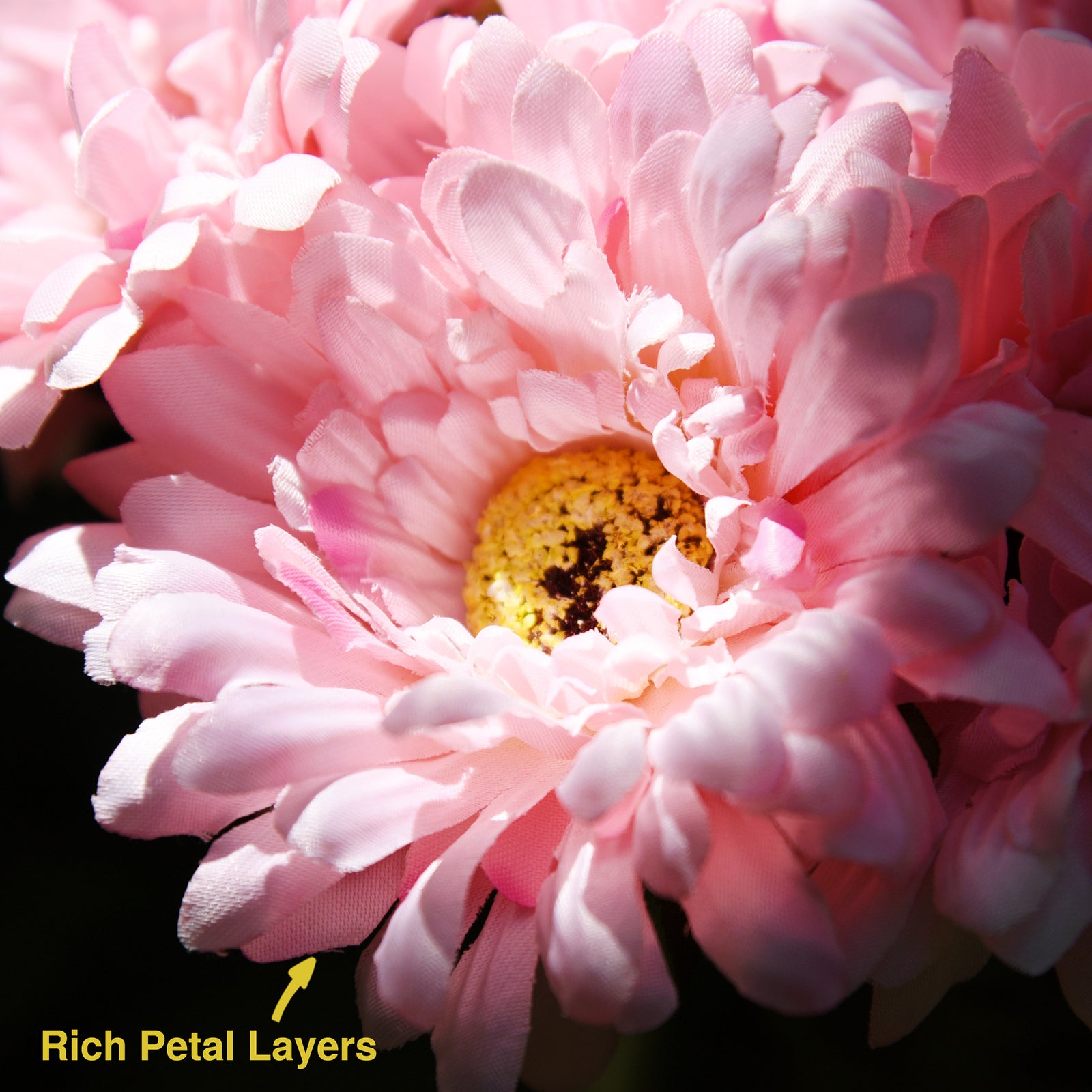 Pink artificial silk gerbera flowers shown with layered blooms and green stems.