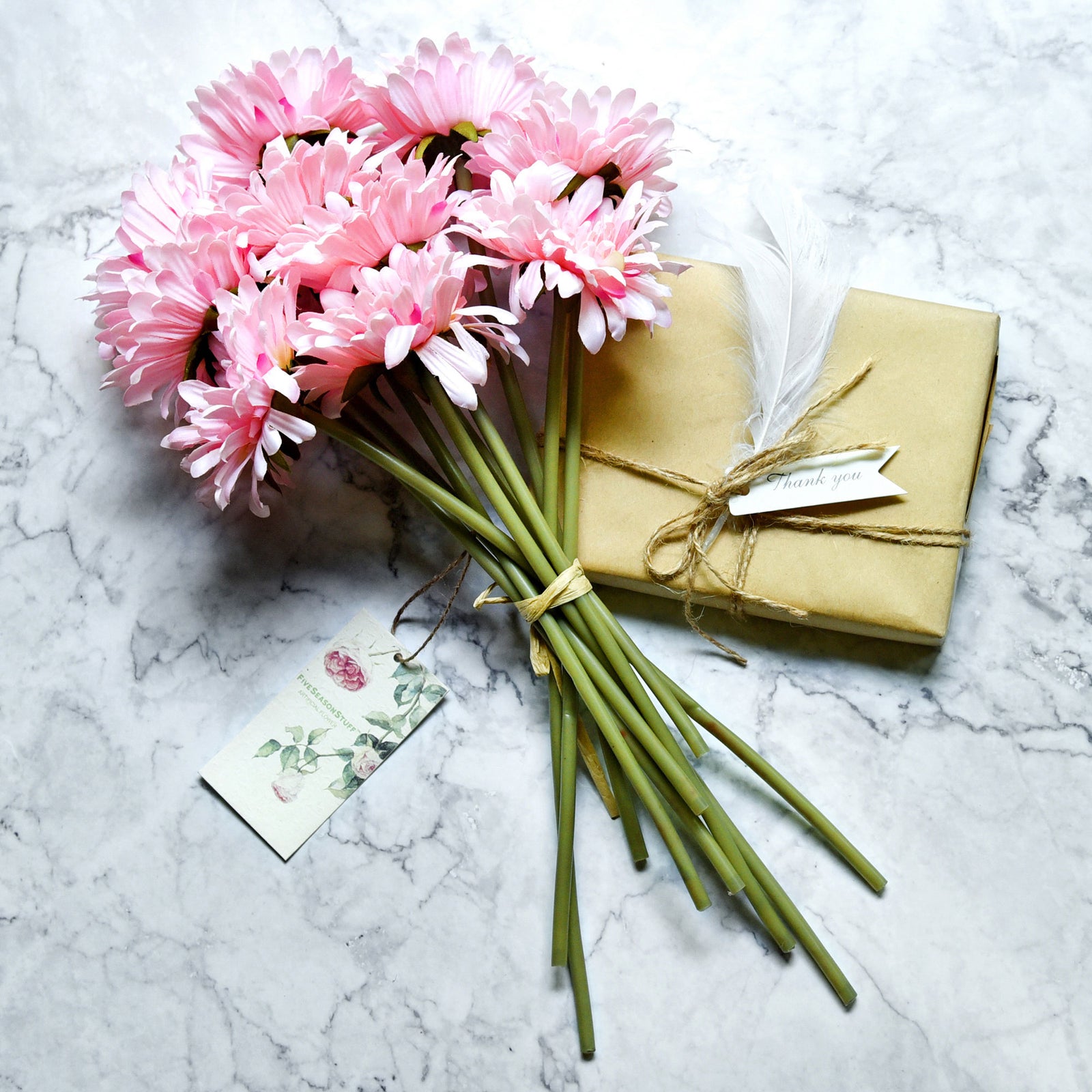 Pink artificial gerbera flower stems shown in an additional arrangement view.