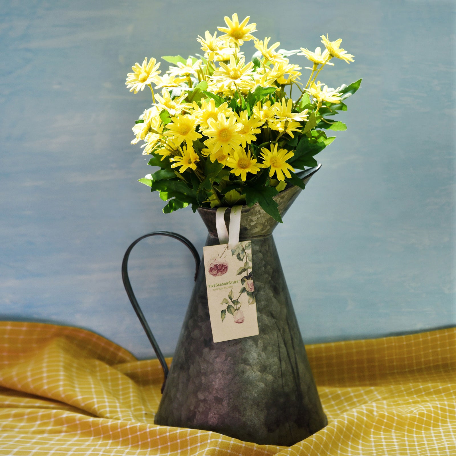 Detail view of Sunny Yellow artificial daisy blooms and green foliage.