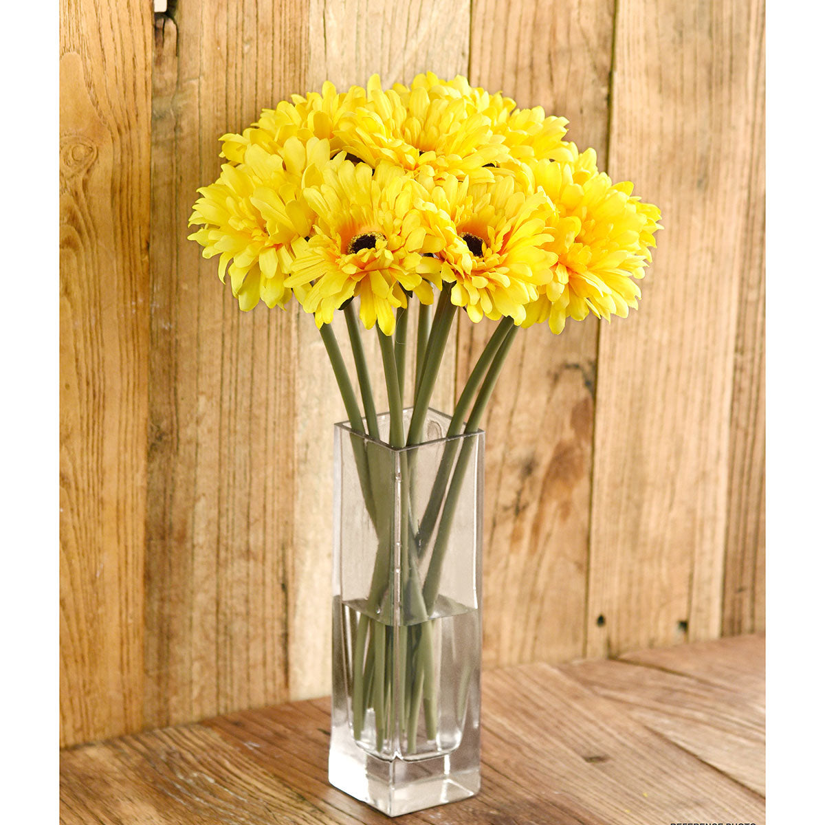 Yellow artificial silk gerbera flowers shown with layered yellow blooms and green stems.